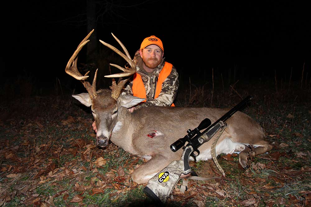 hunter kneeling behind a large kentucky buck