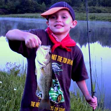 Jonathan Cotton, 5, with his first nice bass that he caught while fishing with his grandfather in New York.