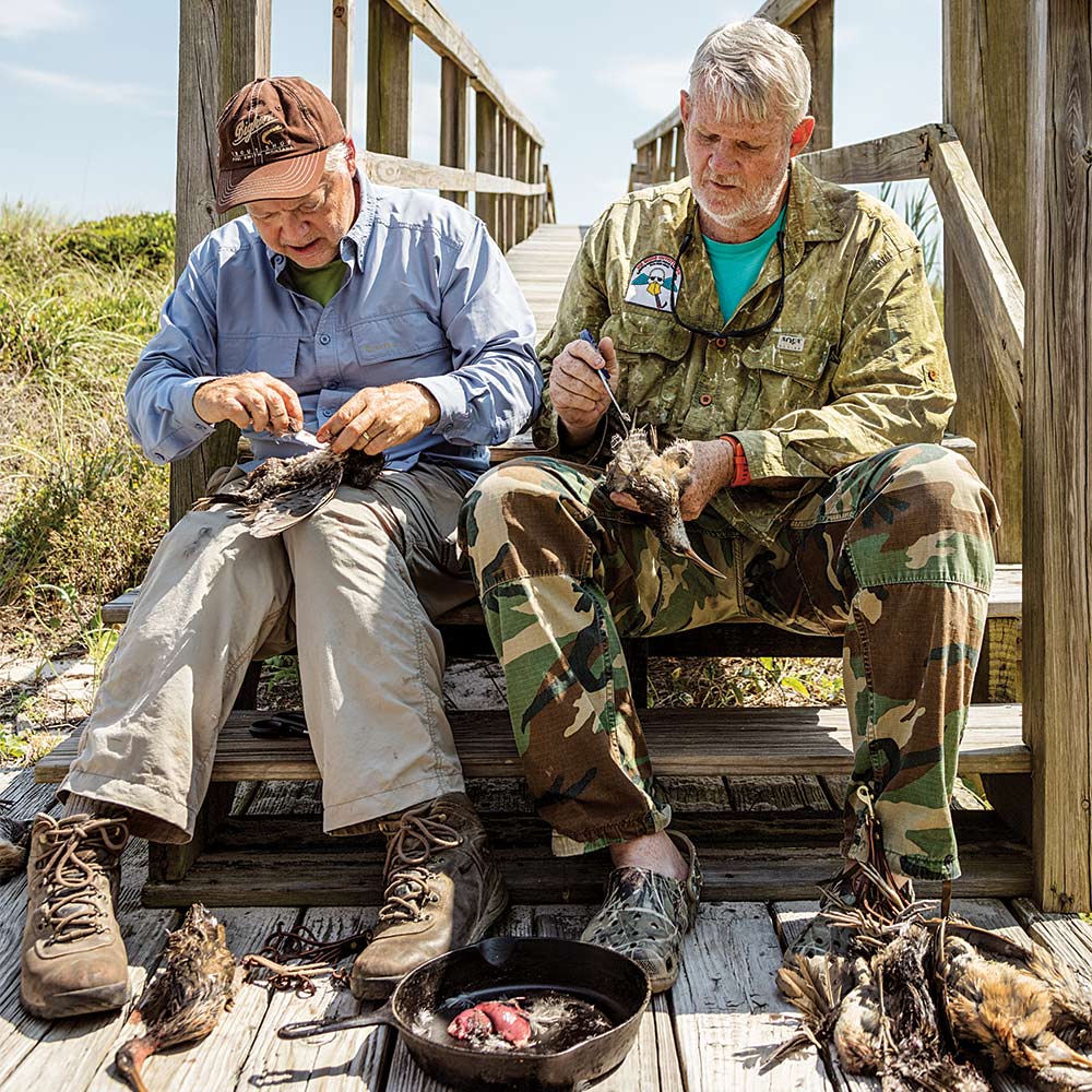 two hunters cleaning rail birds for cooking