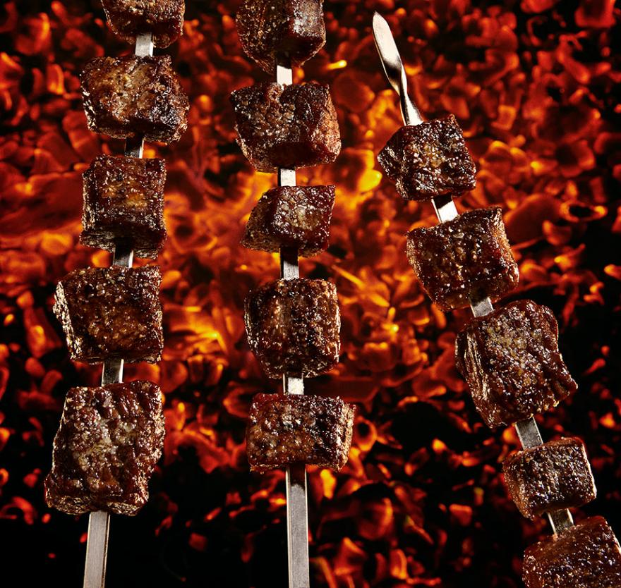 Meat on skewers roasting over a fire. 
