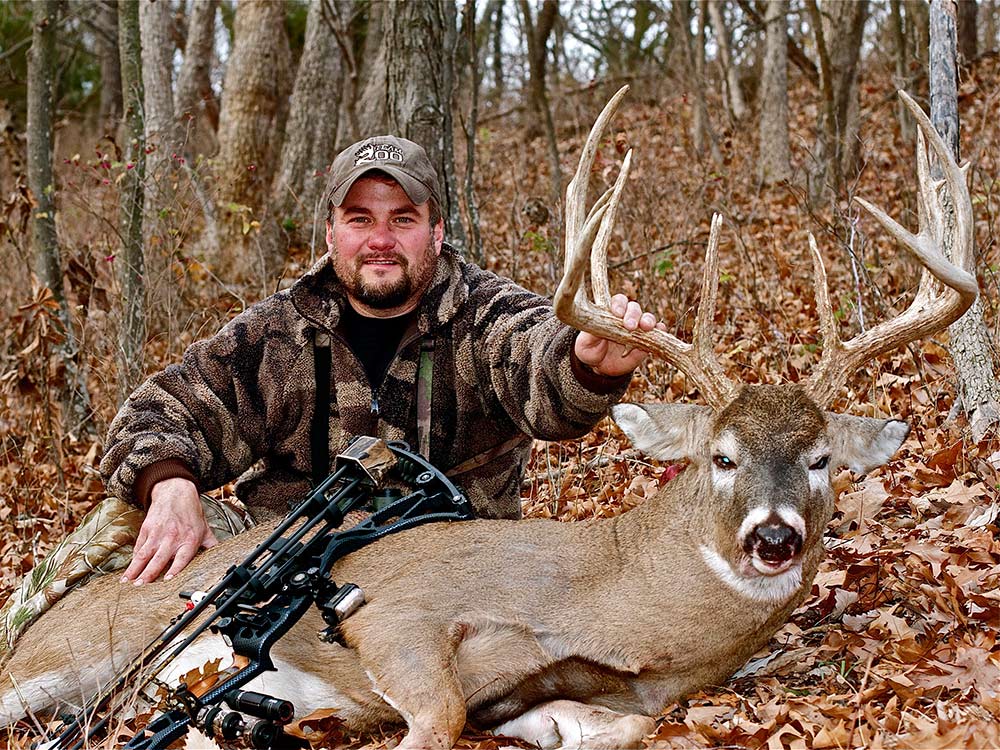Hunter in woods with a trophy buck