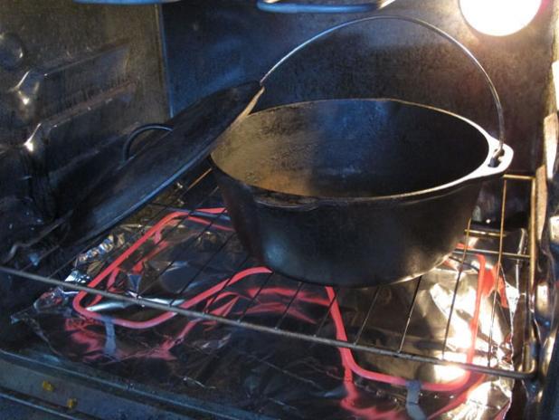 Rinse the cast iron dutch oven and dry it off in the oven.