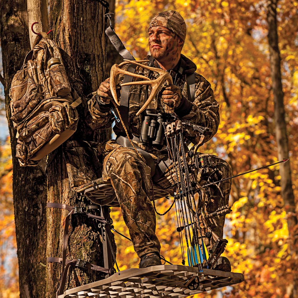 A hunter in tree stand rattling antlers