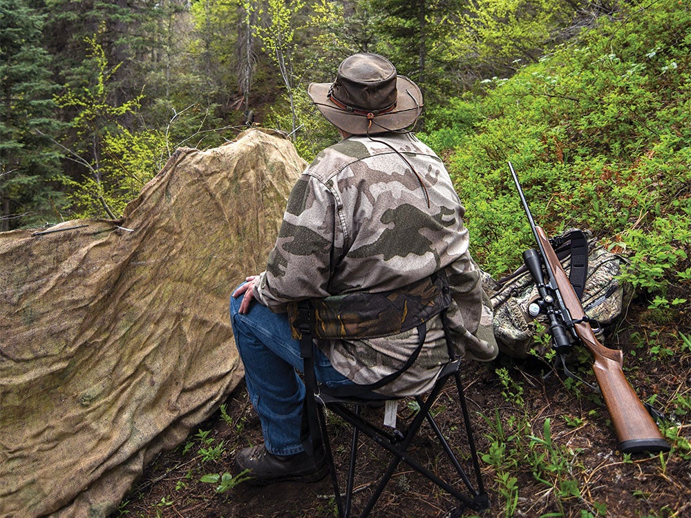 a hunter sitting in a chair overlooking a bear hunt