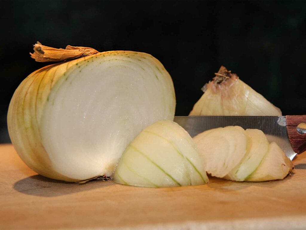 a sliced onion on a wooden cutting board