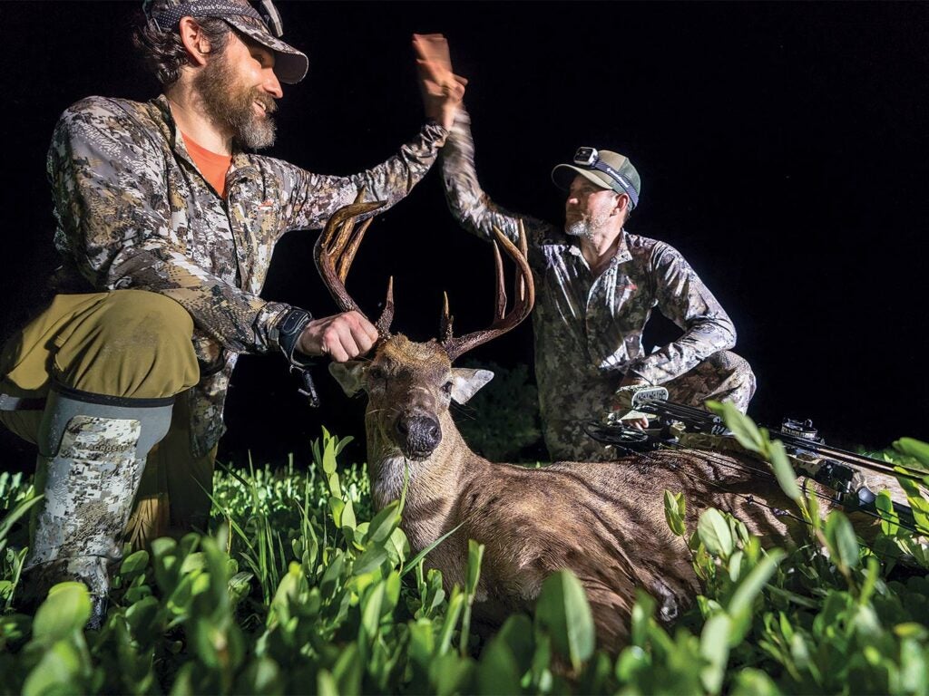 two hunters kneeling over a Florida whitetail buck