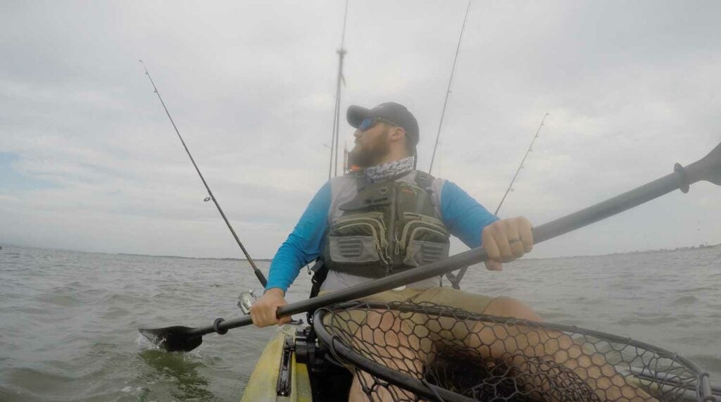 Checking rod tips while trolling for striped bass from a fishing kayak.