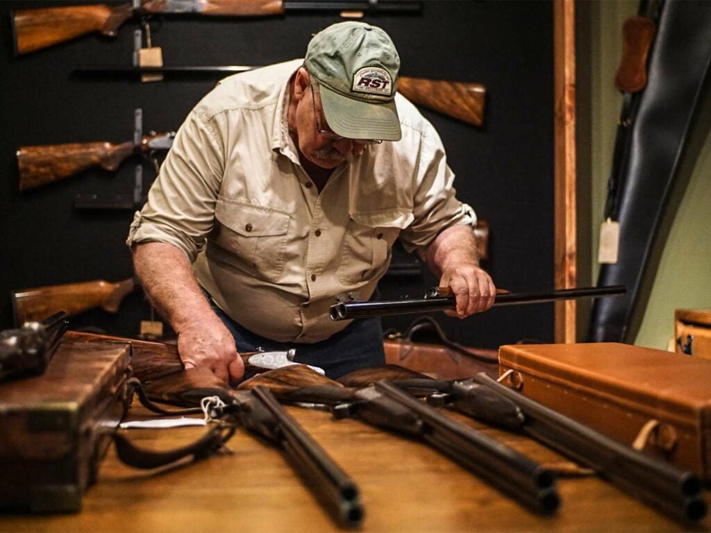 gunsmith inspecting shotgun pieces