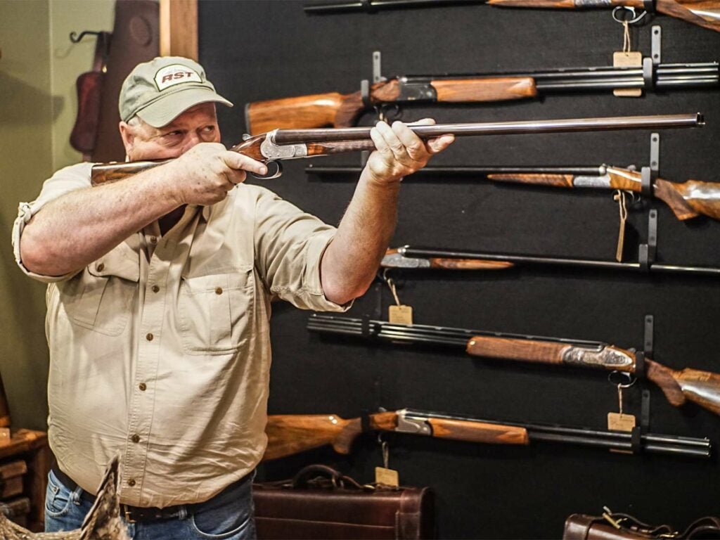man holding shotgun in gun store