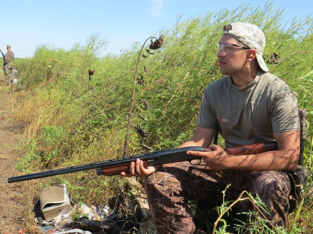 young male hunter holding a shotgun