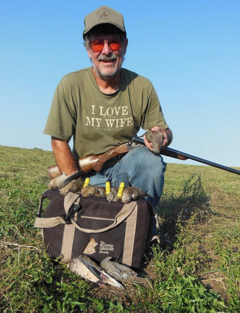 man holding a 20-gauge shotgun and doves