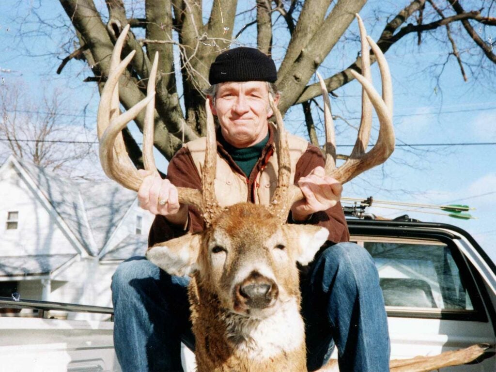 hunter with giant antlered indiana buck