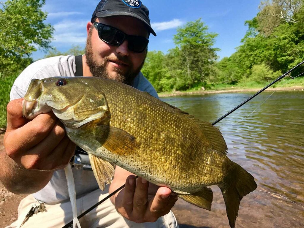 angler holding up a smallmouth bass