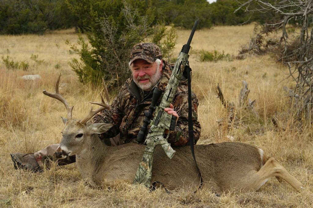 hunter with a cull buck and a remington rifle