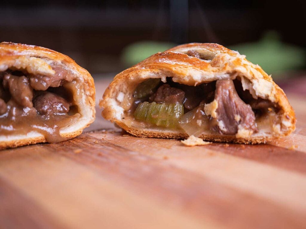 venison steak and kidney hand pies on a wooden cutting board.