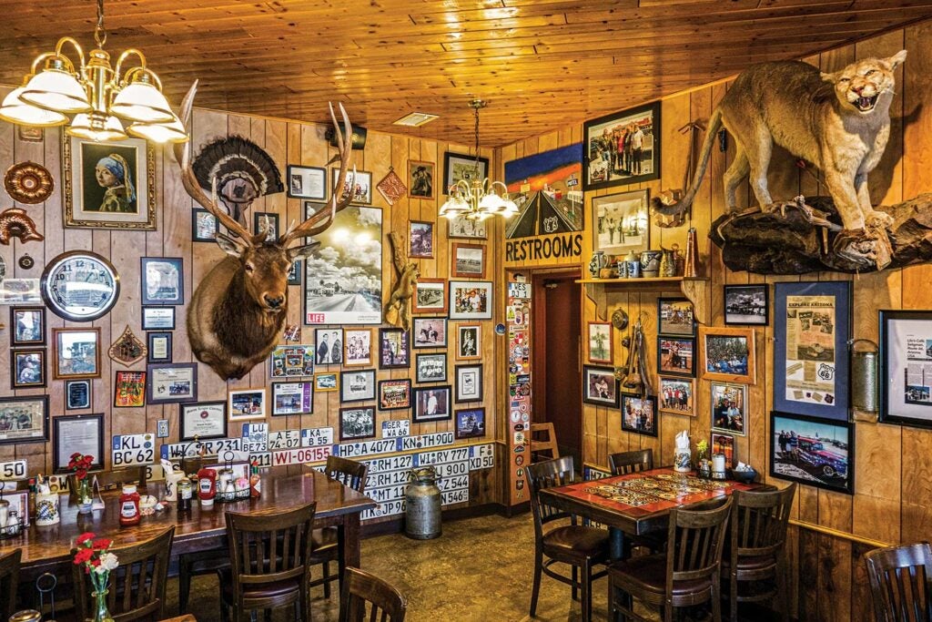 The interior of a diner with pictures and taxidermy on the walls.
