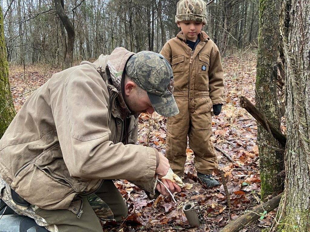 The author and his son bait a Duke Dog Proof raccoon trap.