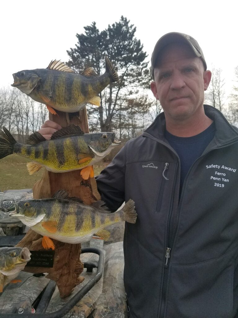 Dean with a taxidermy display of several trophy Finger Lakes perch.