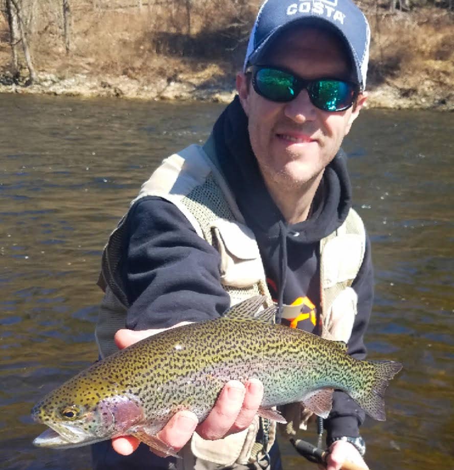 Matt Wettish holding up a rainbow trout.
