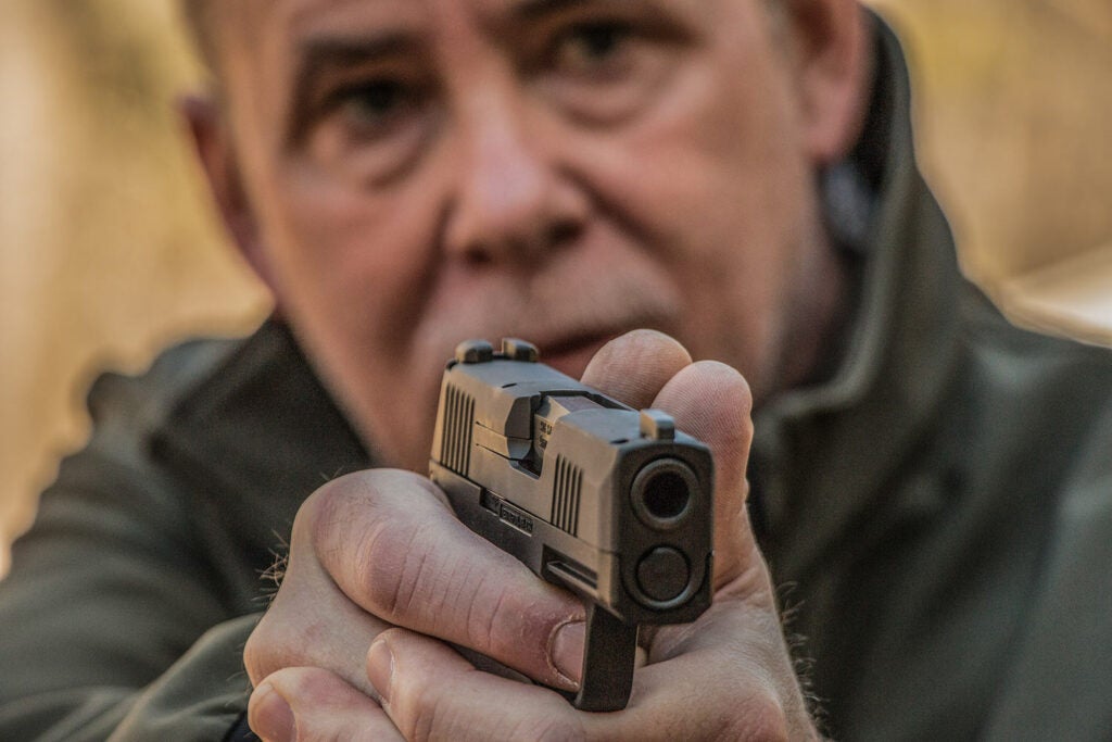 man aiming a handgun