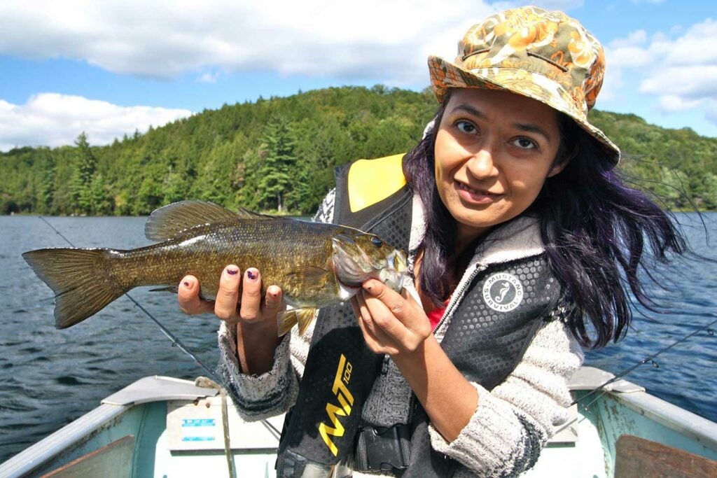 Female angler holding a smallmouth bass.