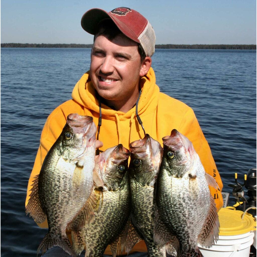 Angler holding up large black crappies.