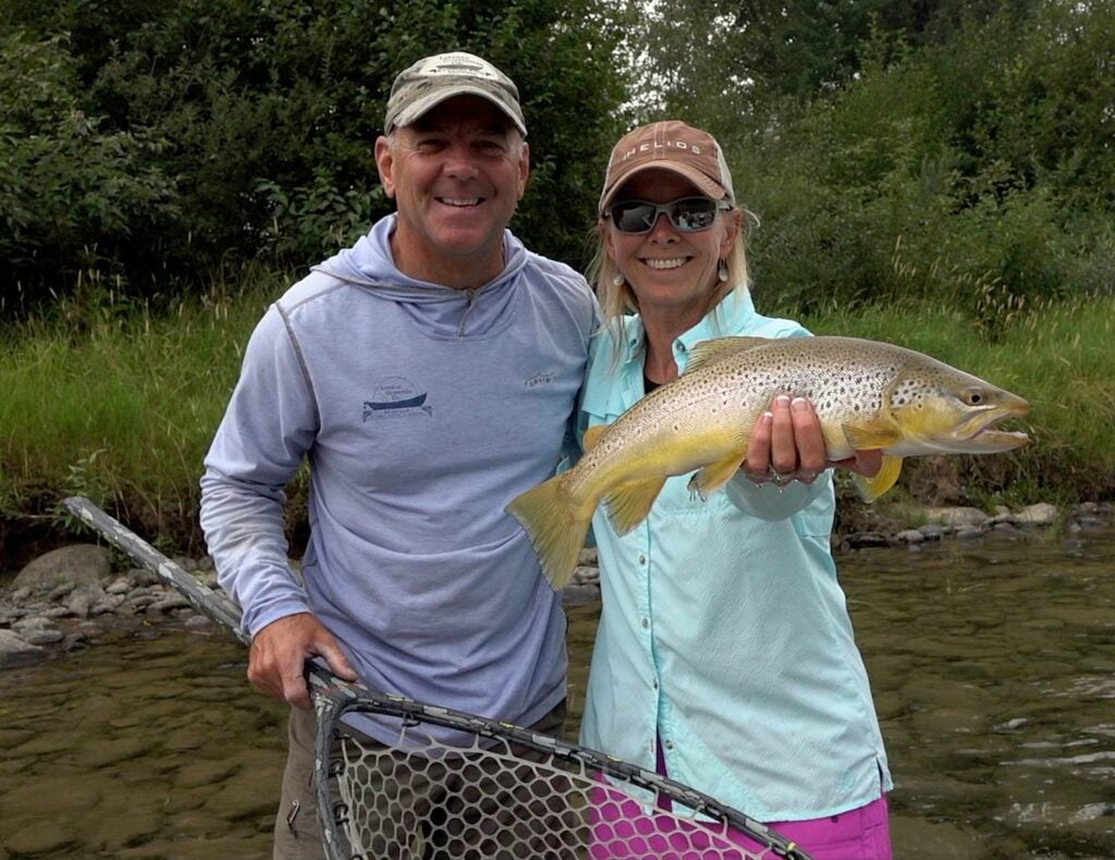 Montana guides Tim and Joanne Lineham holding up a trout.