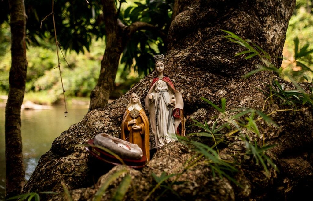Statues of saints look over a river.