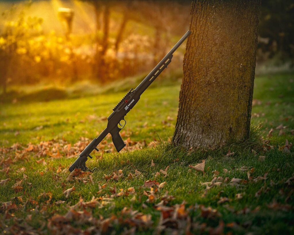 Savage Arms A22 Precision rifle leaning against a tree.