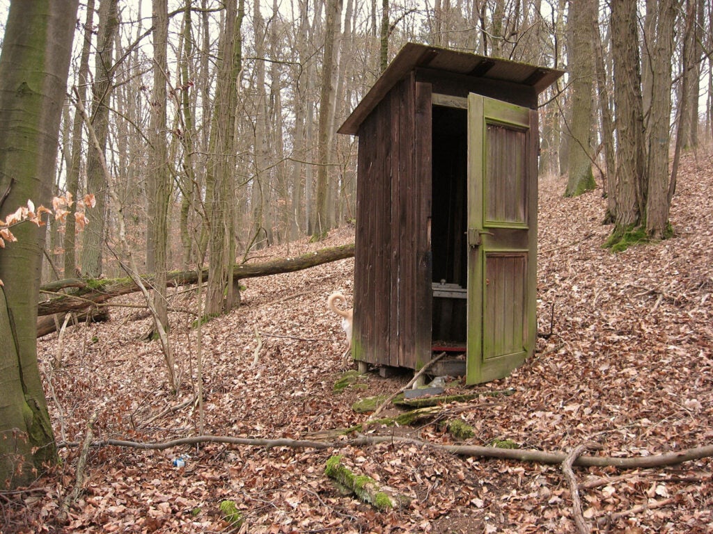 An outhouse in the woods.