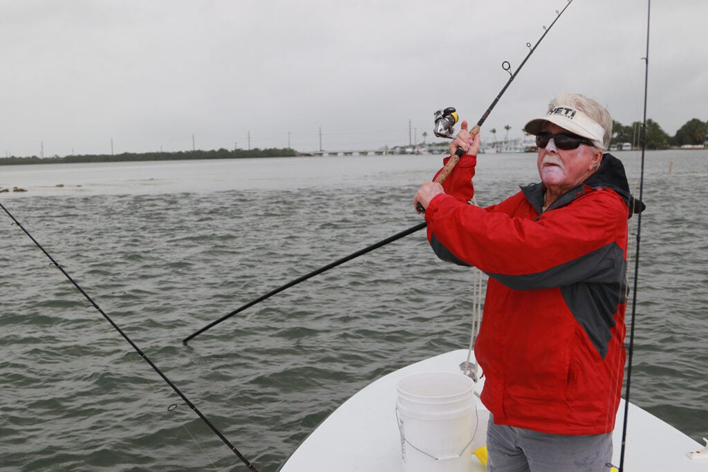 A man in a red jacket casts a line in Florida Keys.