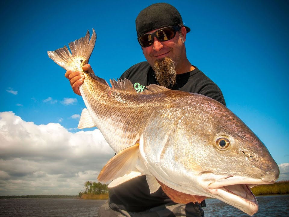 An angler holding up a large redfish.