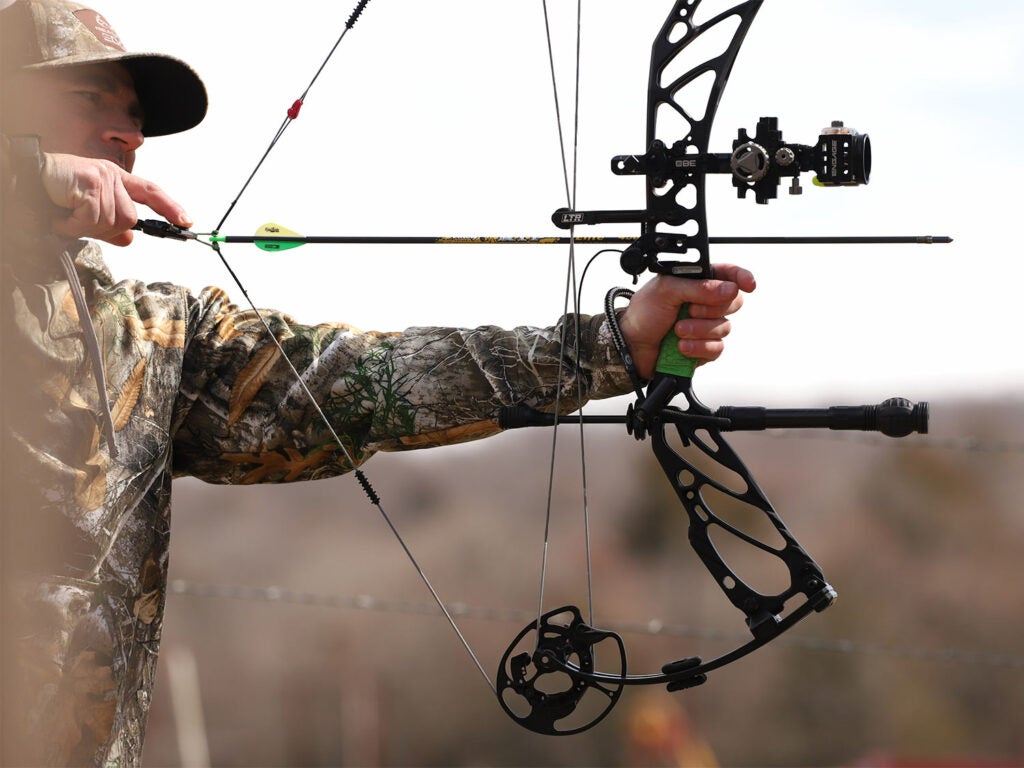 A bowhunter drawing back on a compound bow.