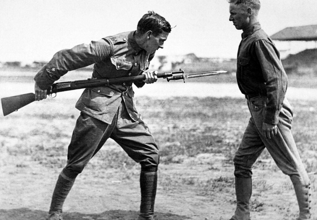 Black and white photograph of two military men training with a bayonet.