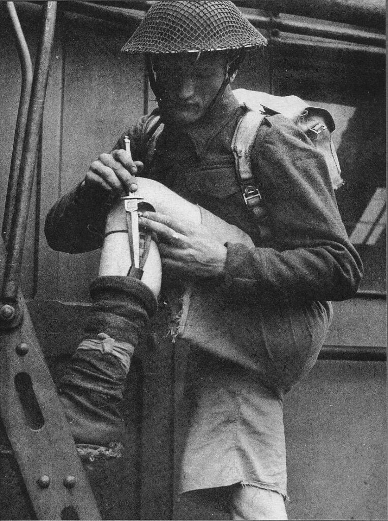 A military officer pulling a knife out of a concealed sheathe.
