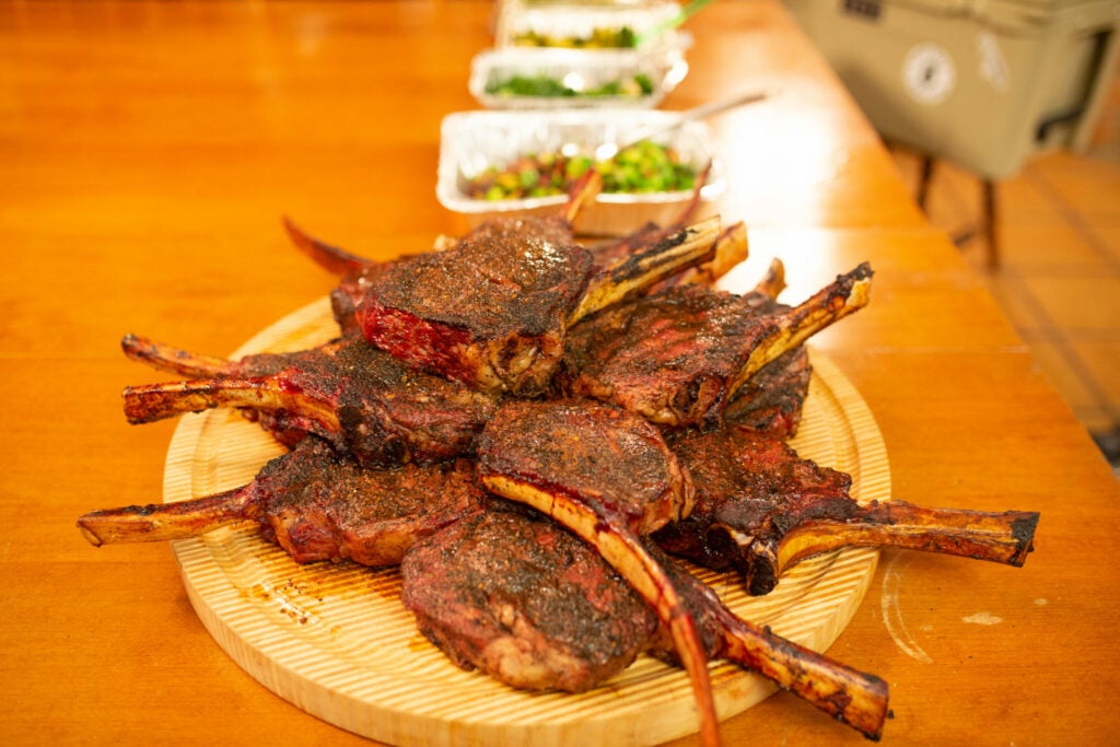 A pile of tomahawk steaks piled on a plate.