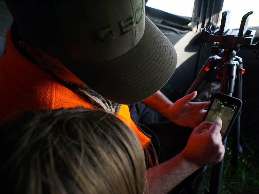 A stepfather shows daughter how to use an app for locating their hunting spot.