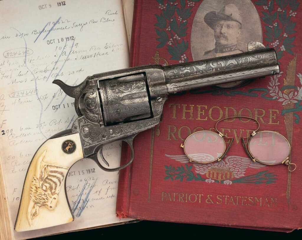A colt single action army revolver on a book of Teddy Roosevelt.