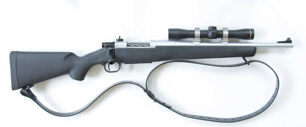 A custom scout rifle built from a Mossberg rifle on a white background.