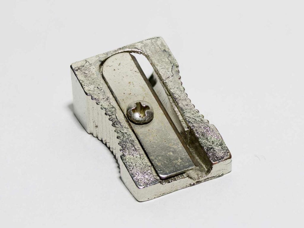 A metal pencil sharpener on a white background.