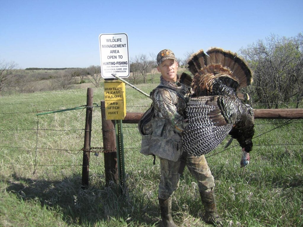 A hunter next to a large public land turkey.