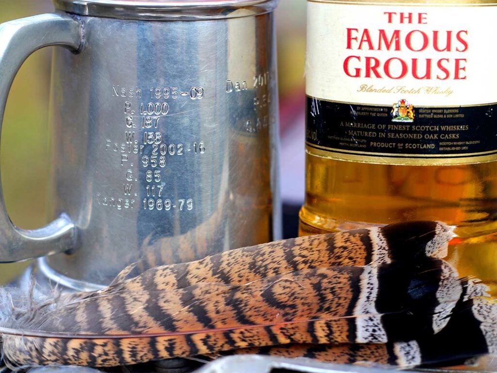 Feathers next to a bottle of scotch.
