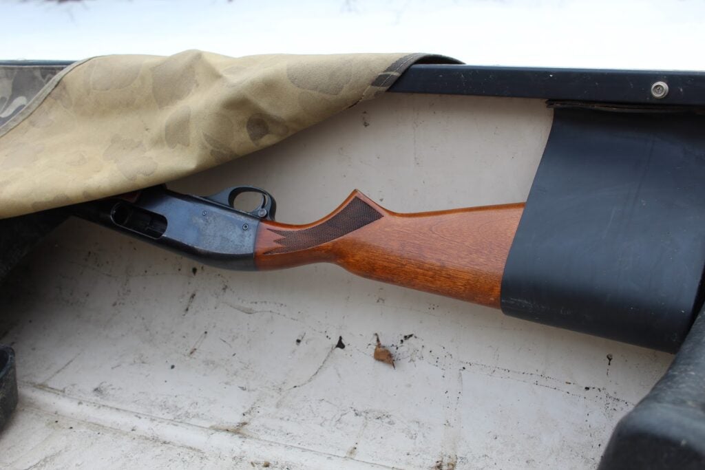 Canvas covering shotgun in canoe gun rack.