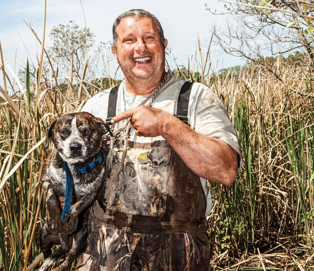 Hunter holding a bluetick hunting dog.